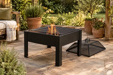 Brasero carré noir en métal avec grille et pare-étincelles, installé sur une terrasse de jardin