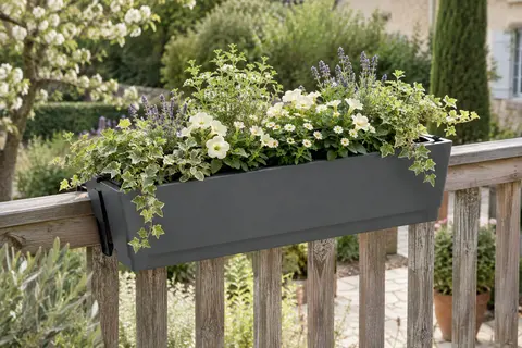 Jardinière Lechuza rectangulaire gris ardoise garnie de fleurs sur une rambarde de balcon