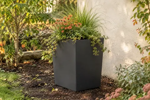 Pot de fleurs Prosperplast Urbi carré anthracite avec insert, installé dans un jardin aux feuillages d’automne.