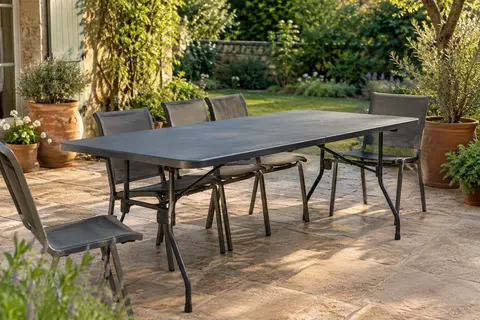 Table de jardin pliante anthracite avec plateau en plastique et structure en acier, installée sur une terrasse