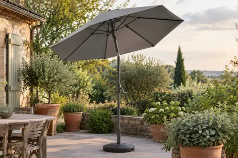 Parasol de jardin gris Vounot incliné sur un patio verdoyant, avec toile octogonale et structure métallique.